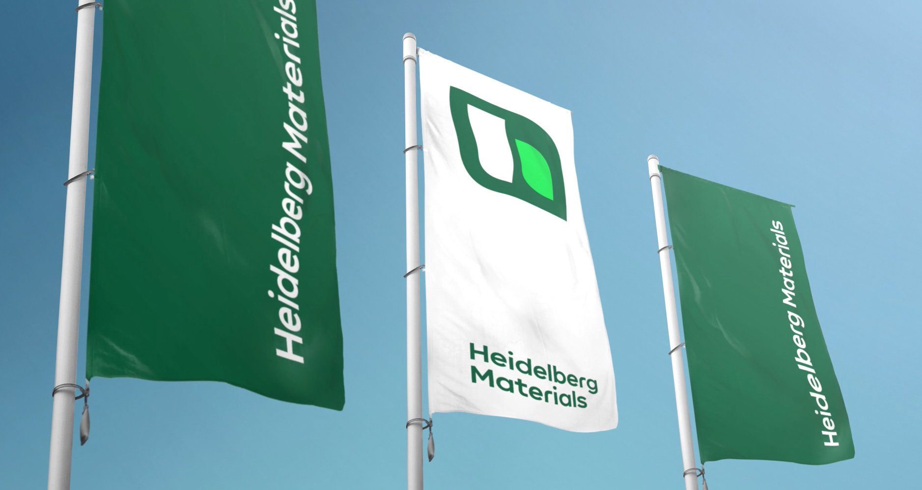 Three flags in the wind with the Heidelberg Materials logo on them